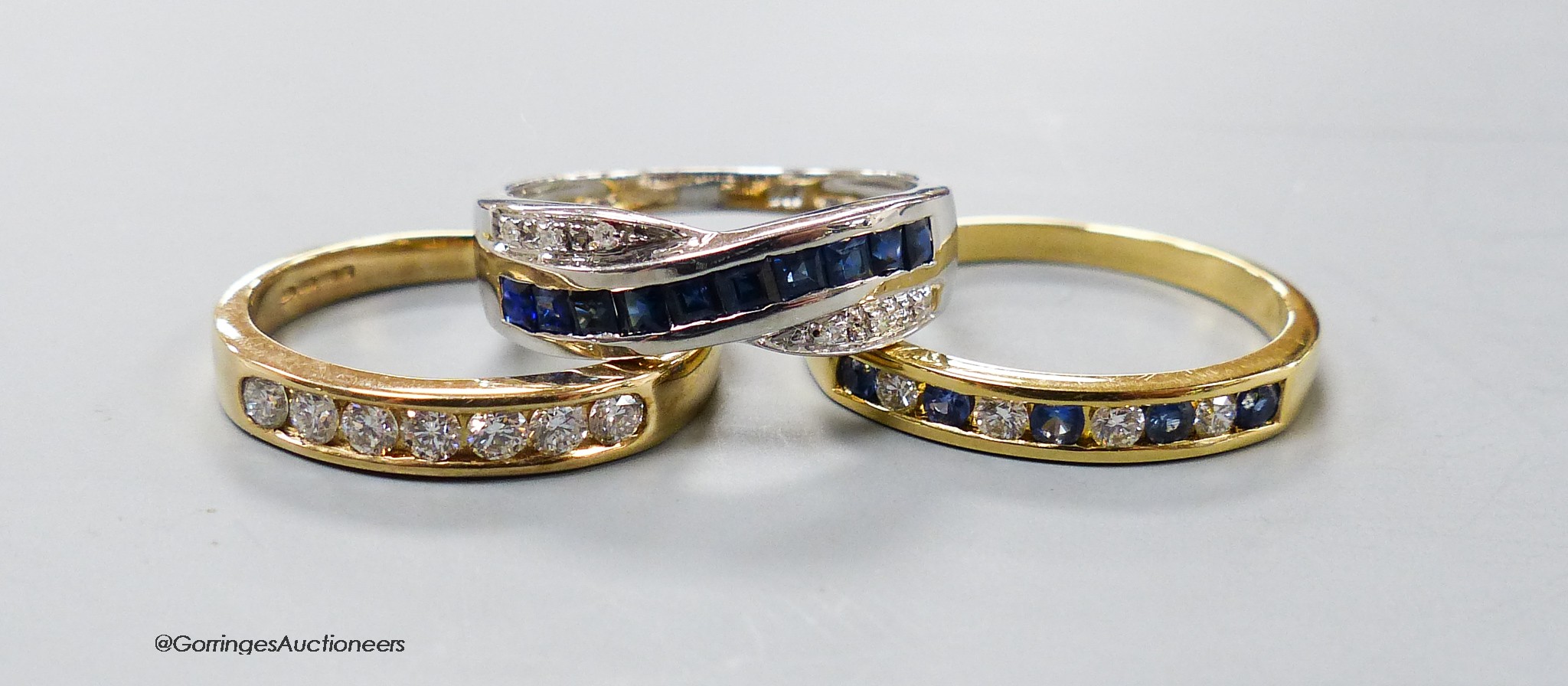 A modern 18ct gold and channel set sapphire and diamond half hoop ring, size R, gross 3 grams and two modern 9ct gold and gem set rings, gross 4.3 grams
